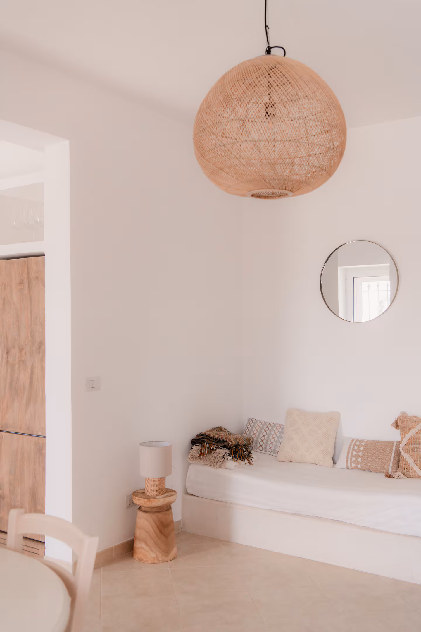 Living area with a large rattan pendant light and a stone bench